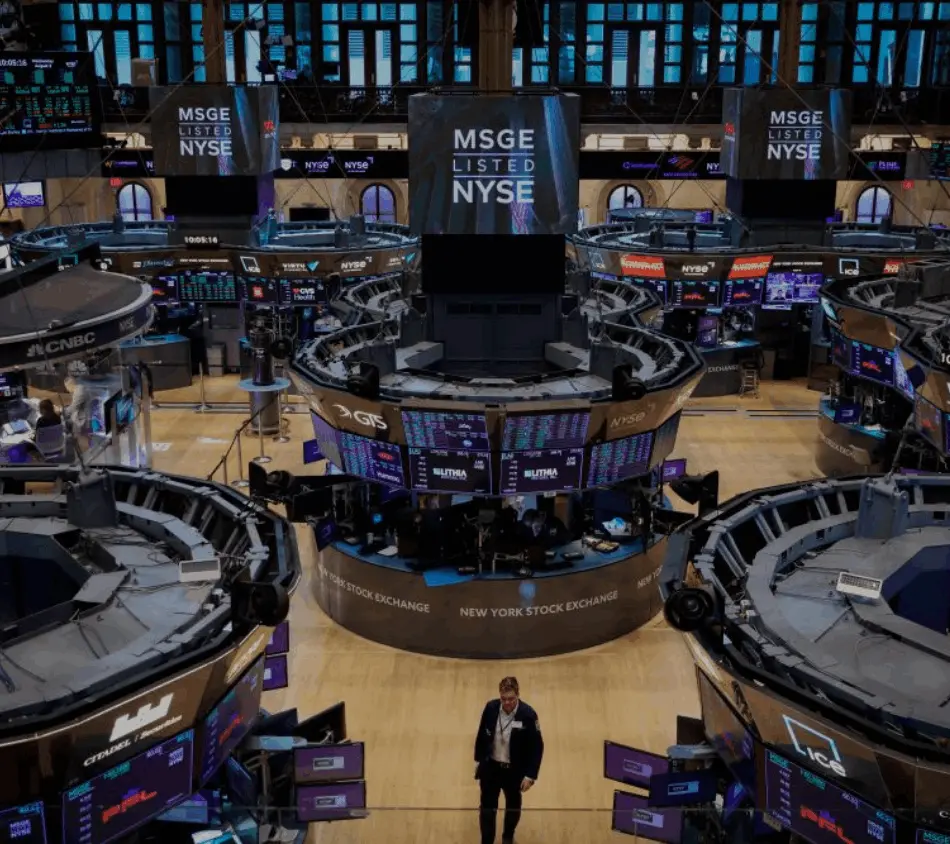 New York Stock Exchange (NYSE), surrounded by trading desks and monitors displaying financial data and stock information